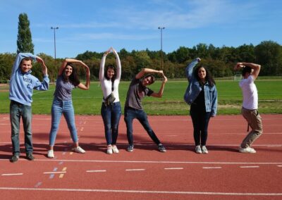 défi photo d'étudiants sur une piste d'athlétisme lors des olympiades de journée d'intégration